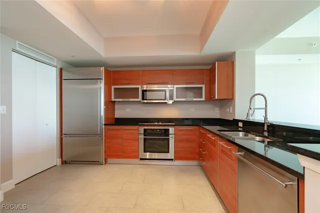 a kitchen with stainless steel appliances granite countertop a refrigerator and a sink