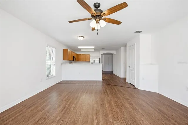a view of a livingroom with a ceiling fan and wooden floor