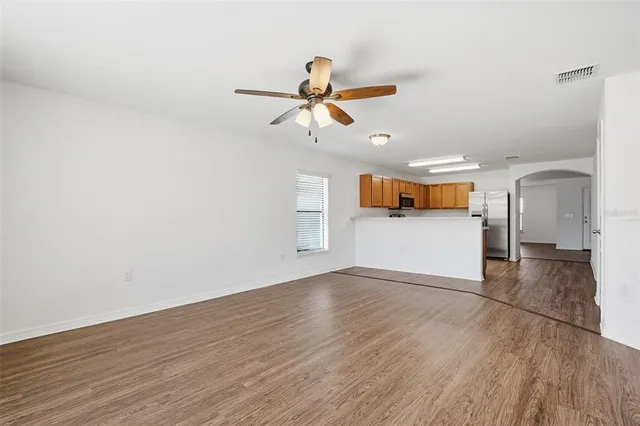 a view of a kitchen with wooden floor and a ceiling fan