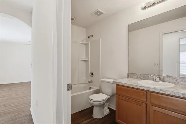 a bathroom with a granite countertop toilet a sink and a shower