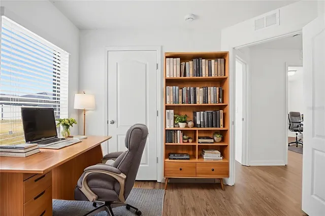 a view of a workspace with furniture and a bookshelf