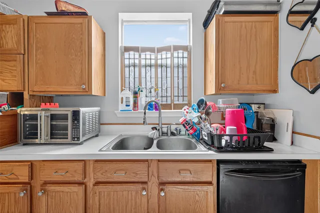 a kitchen with sink a window and cabinets
