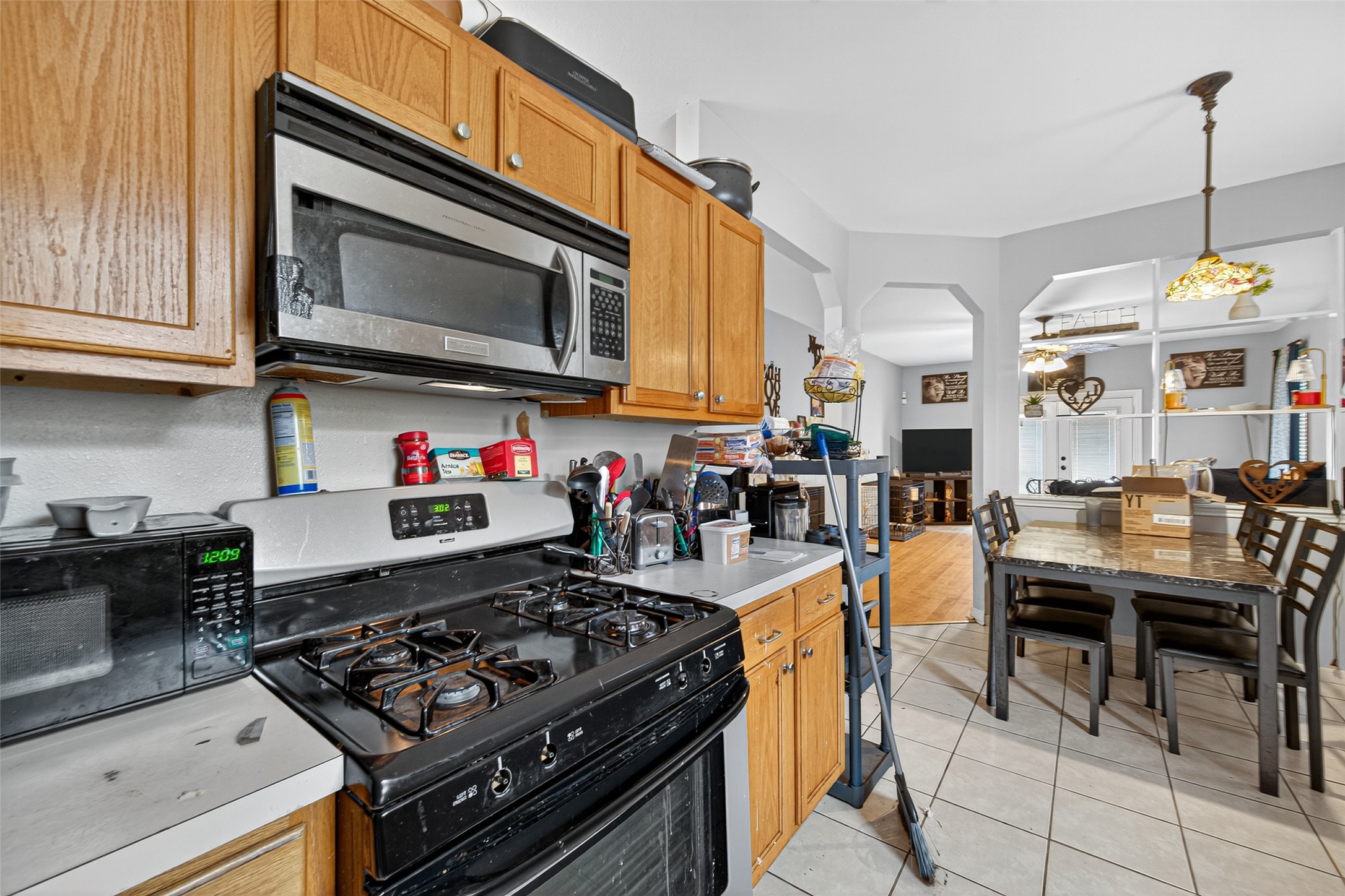 907 Morley Park Lane Spring, TX 77373 - Photo 27 of 44 a kitchen with stainless steel appliances kitchen island granite countertop a stove a sink and a microwave