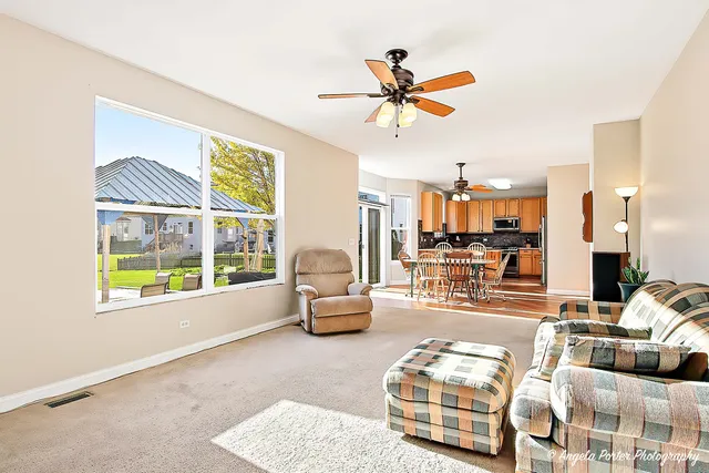 a view of a livingroom with a chandelier fan and windows