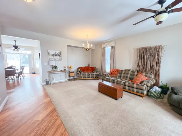 a living room with furniture ceiling fan and a flat screen tv