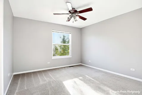 a view of a livingroom with a chandelier fan and windows