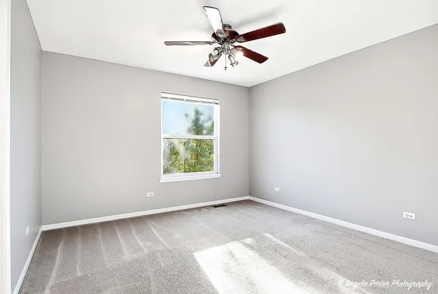 a view of a livingroom with a chandelier fan and windows