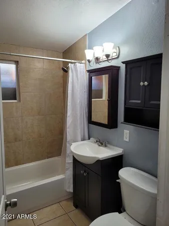a bathroom with a sink vanity mirror bathtub shower and toilet