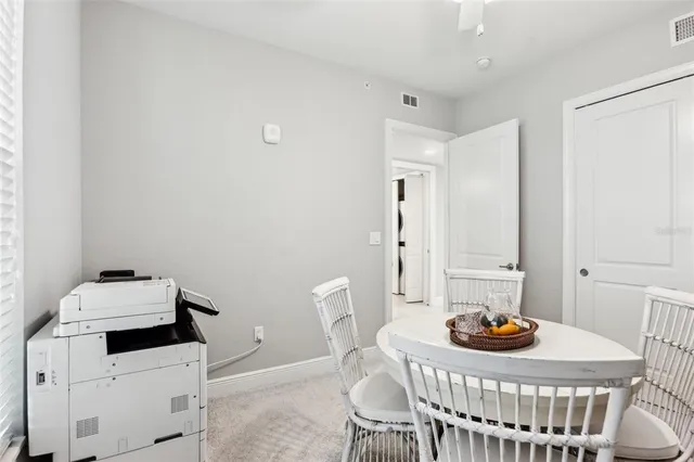 a kitchen with stainless steel appliances a microwave a sink a stove a refrigerator cabinets and a dining table