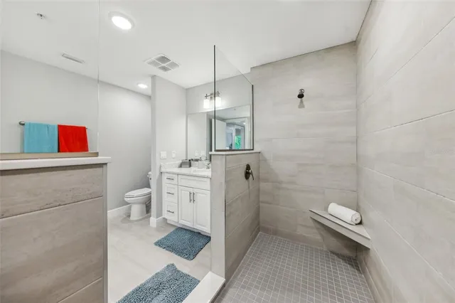 a bathroom with a granite countertop sink a toilet and shower