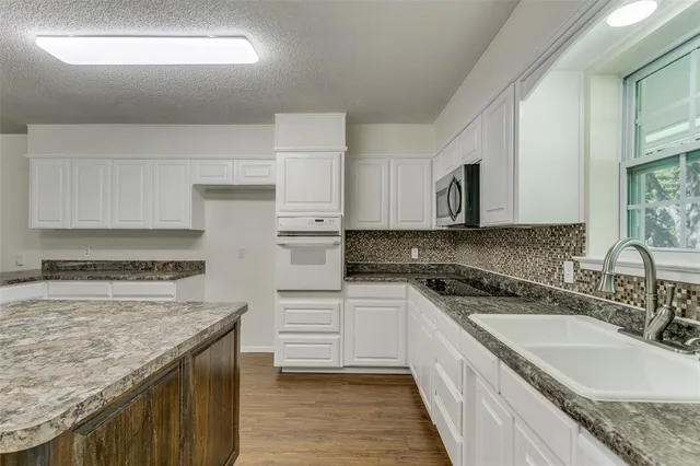 a kitchen with a sink stove and cabinets