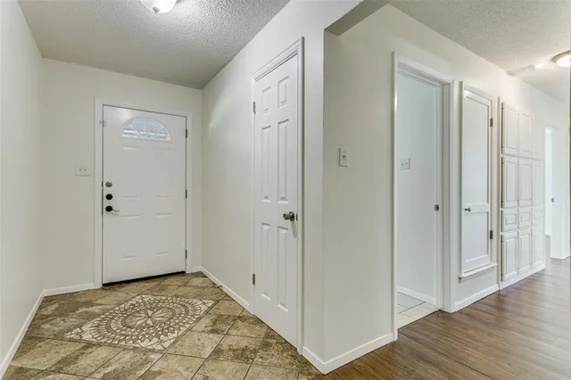 a view of a hallway with wooden floor and closet