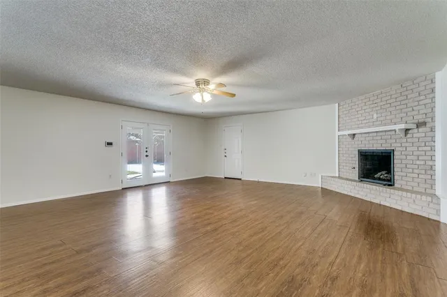 an empty room with wooden floor and fireplace