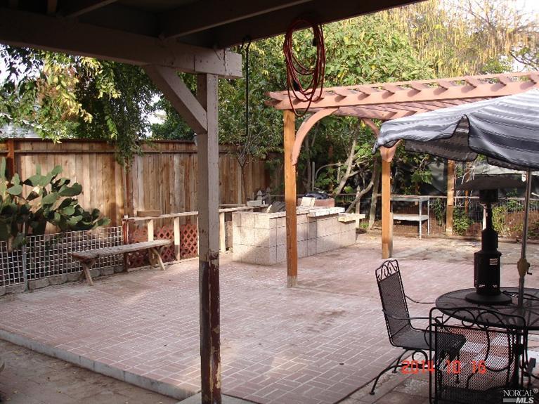 a view of a patio with table and chairs potted plants with wooden floor and fence