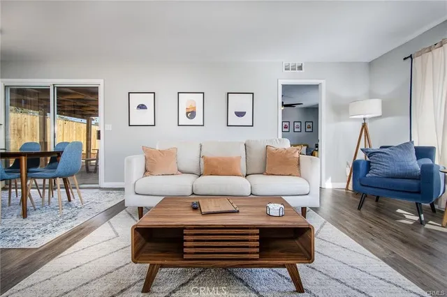 a living room with furniture a wooden floor and a lamp