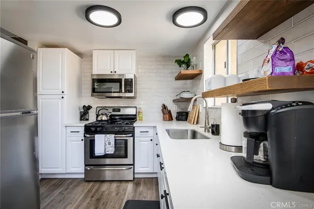 a kitchen with stainless steel appliances granite countertop a stove a refrigerator and a microwave