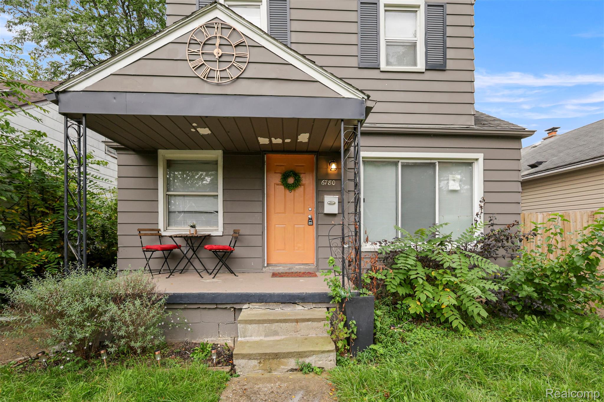 6780 Rutland Street Detroit, MI 48228 - Photo 3 of 35 Covered front porch with decorative iron columns, a contrasting entry door, and horizontal siding