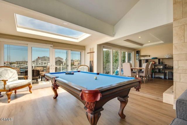 a room with pool table and windows