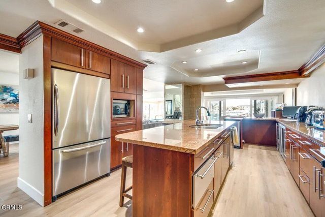 a kitchen with stainless steel appliances granite countertop a refrigerator a sink and a stove