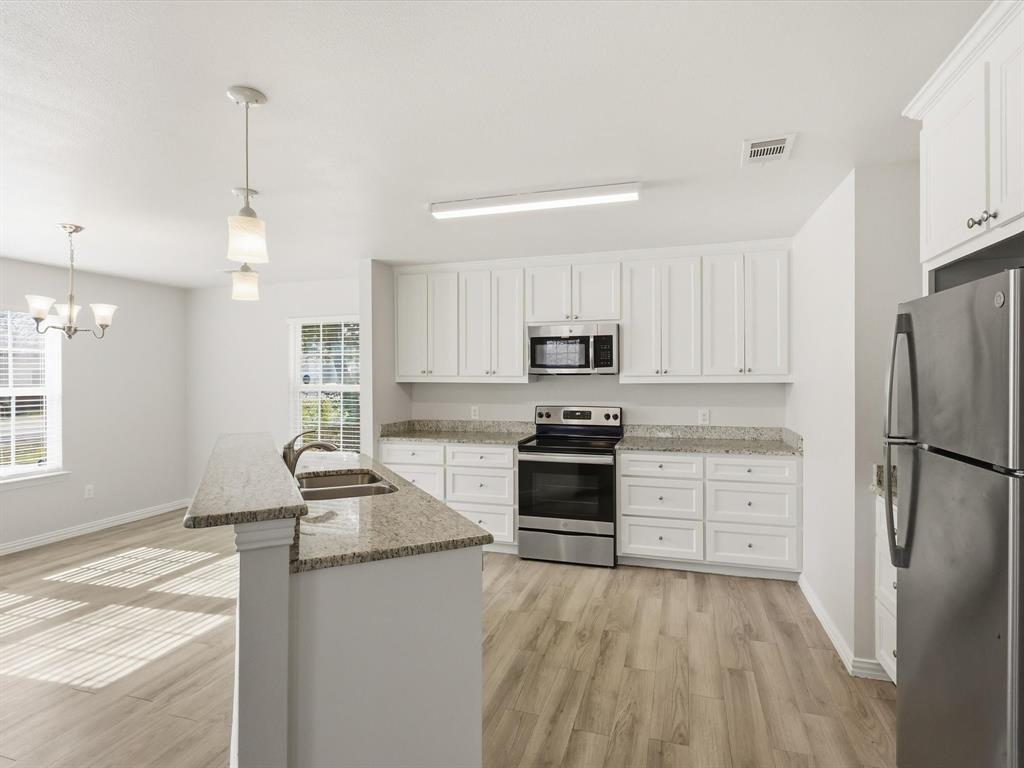6409 Ramey Avenue Fort Worth, TX 76112 - Photo 16 of 25 a kitchen with granite countertop a refrigerator stove and sink