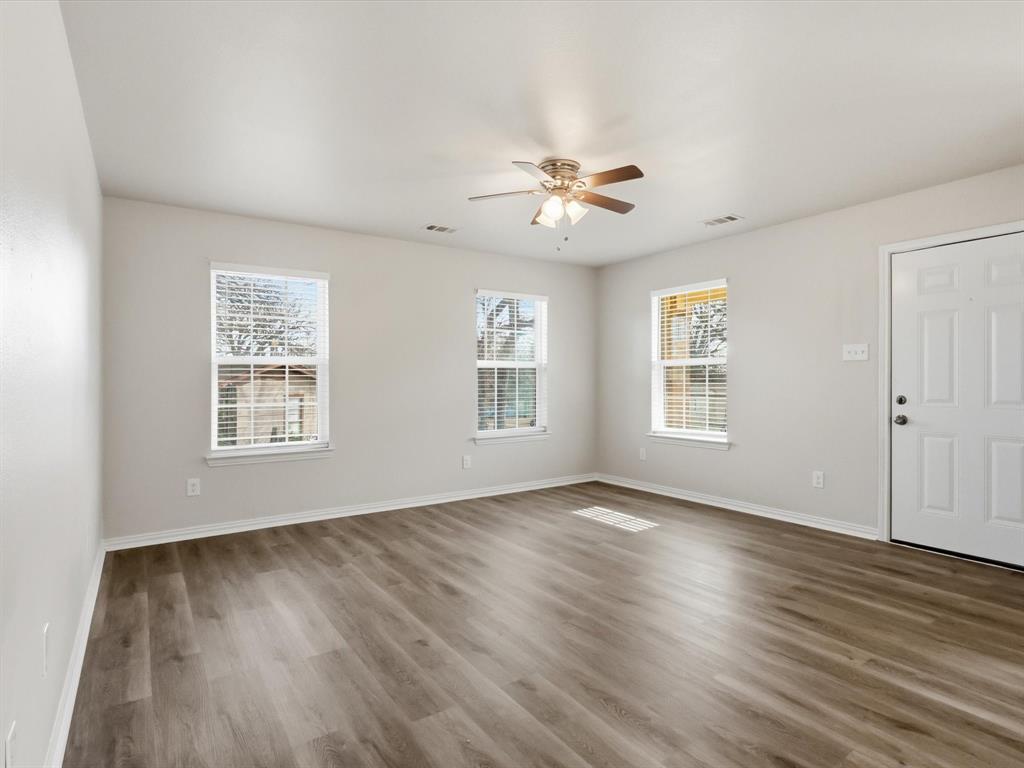 6409 Ramey Avenue Fort Worth, TX 76112 - Photo 7 of 25 a view of an empty room with a window and wooden floor