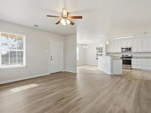 a view of kitchen with granite countertop cabinets and refrigerator