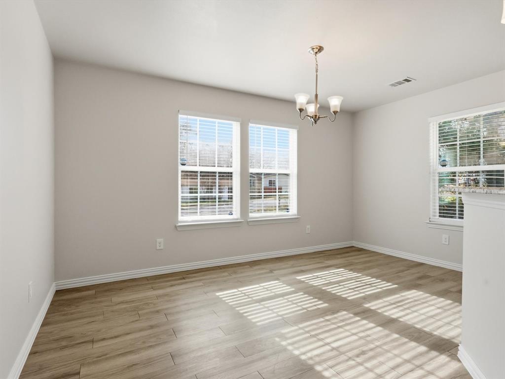 6409 Ramey Avenue Fort Worth, TX 76112 - Photo 10 of 25 a view of a room with window wooden floor and a ceiling fan