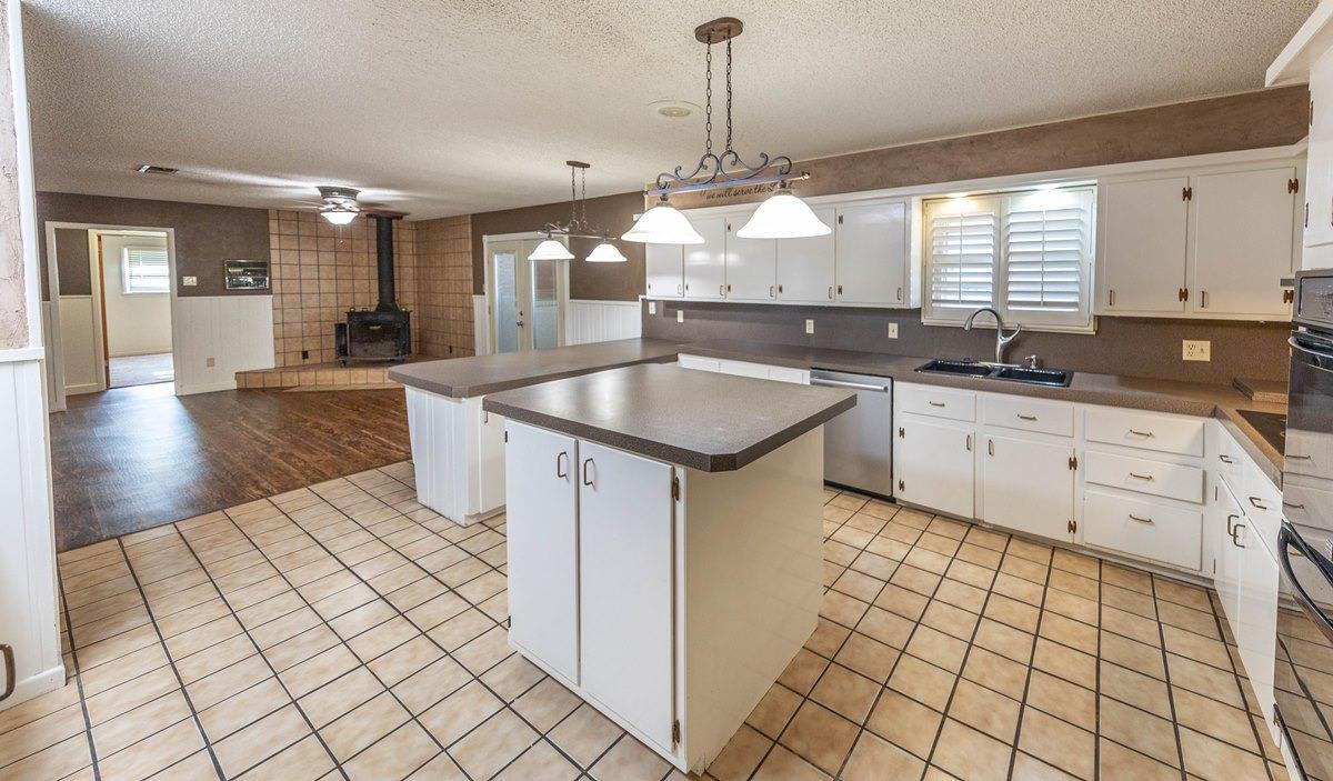 5415 8th Street Lubbock, TX 79416 - Photo 14 of 27 a kitchen with granite countertop a sink a counter top space cabinets and stainless steel appliances