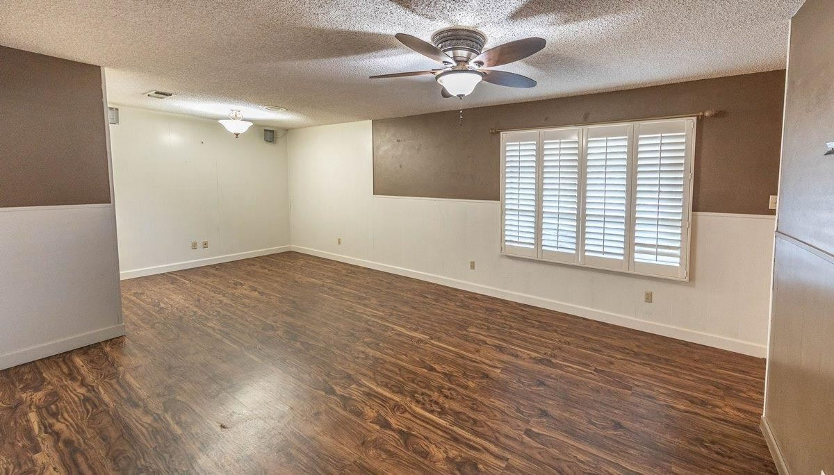 5415 8th Street Lubbock, TX 79416 - Photo 15 of 27 a view of empty room with wooden floor and fan