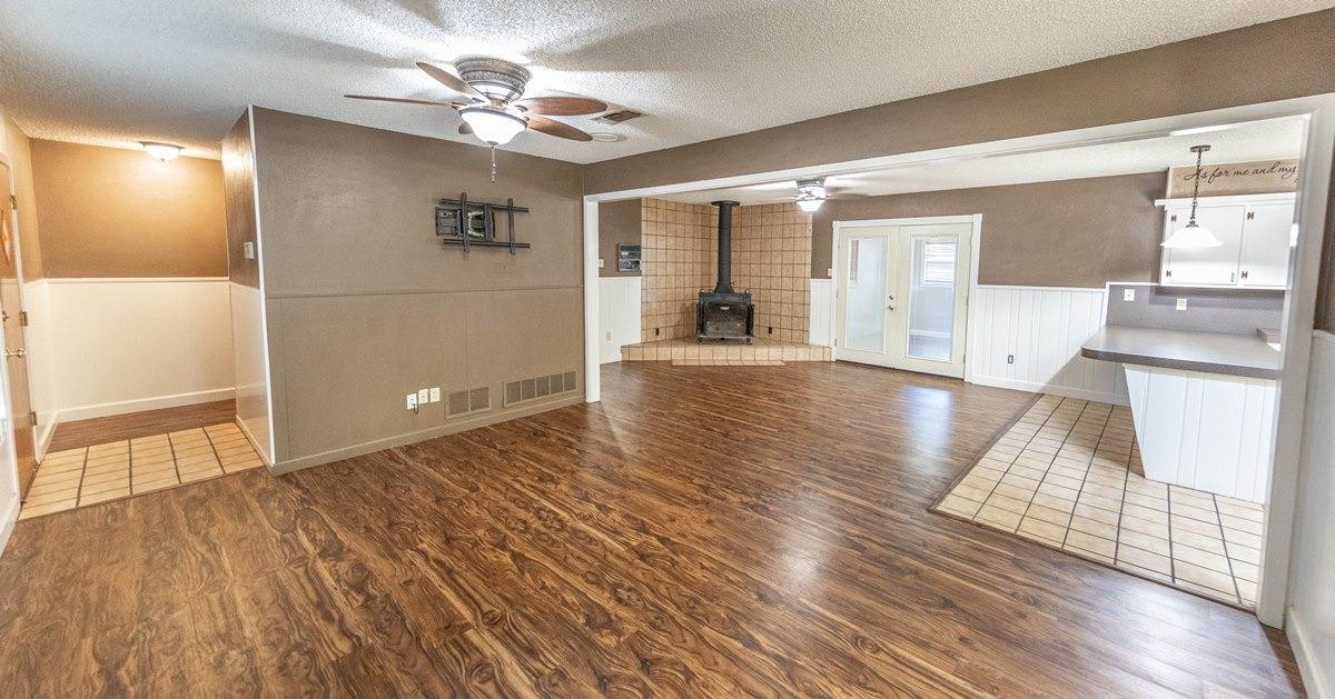 5415 8th Street Lubbock, TX 79416 - Photo 18 of 27 a view of an empty room with wooden floor and a kitchen