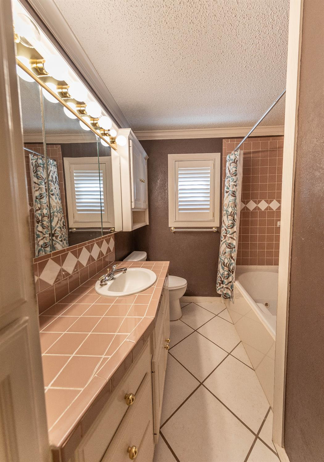 5415 8th Street Lubbock, TX 79416 - Photo 19 of 27 a bathroom with a sink and a mirror
