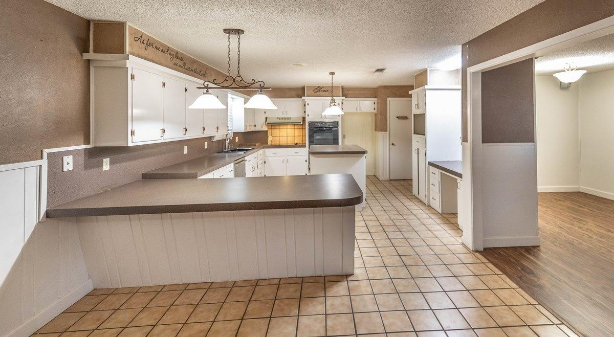 5415 8th Street Lubbock, TX 79416 - Photo 3 of 27 a large kitchen with stainless steel appliances a large counter top a refrigerator and a sink