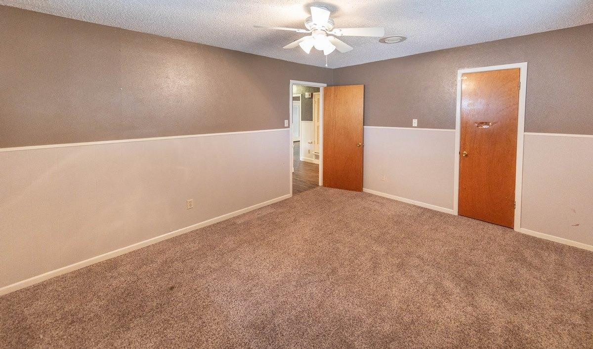 5415 8th Street Lubbock, TX 79416 - Photo 5 of 27 an empty room with a chandelier fan and closet area