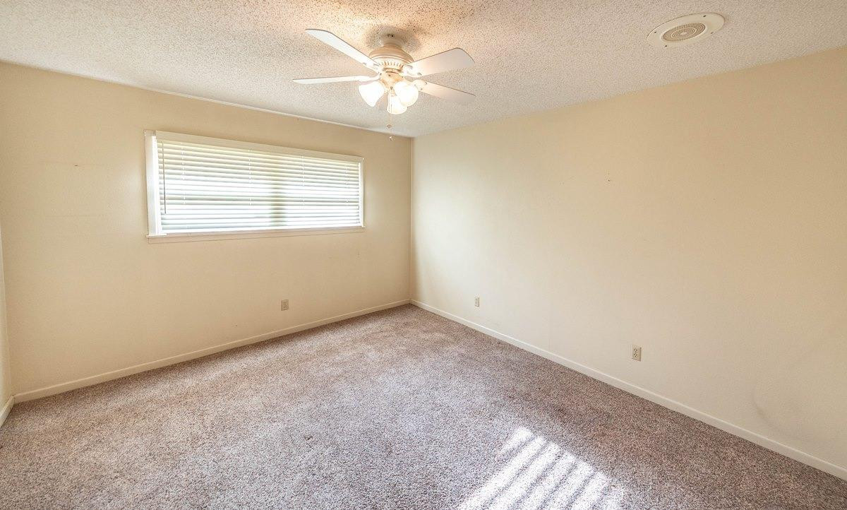 5415 8th Street Lubbock, TX 79416 - Photo 10 of 27 an empty room with a window and a ceiling fan