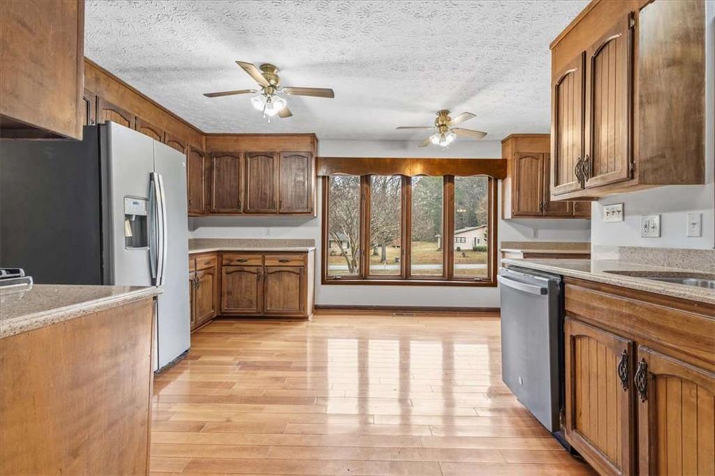 202 Ridgewood Road Cedartown, GA 30125 - Photo 11 of 39 a kitchen with stainless steel appliances granite countertop a refrigerator a sink dishwasher a stove and white countertops with wooden floor