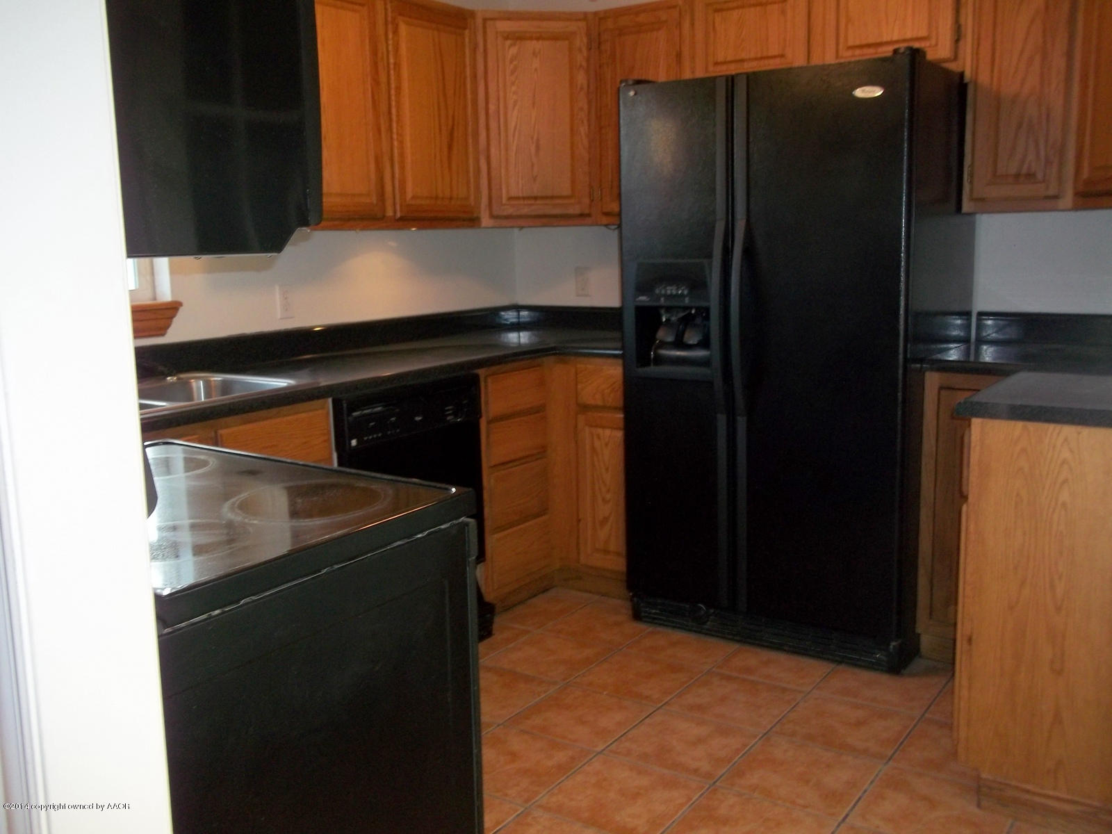4208 South Hughes Street Amarillo, TX 79110 - Photo 5 of 16 a kitchen with a refrigerator and cabinets
