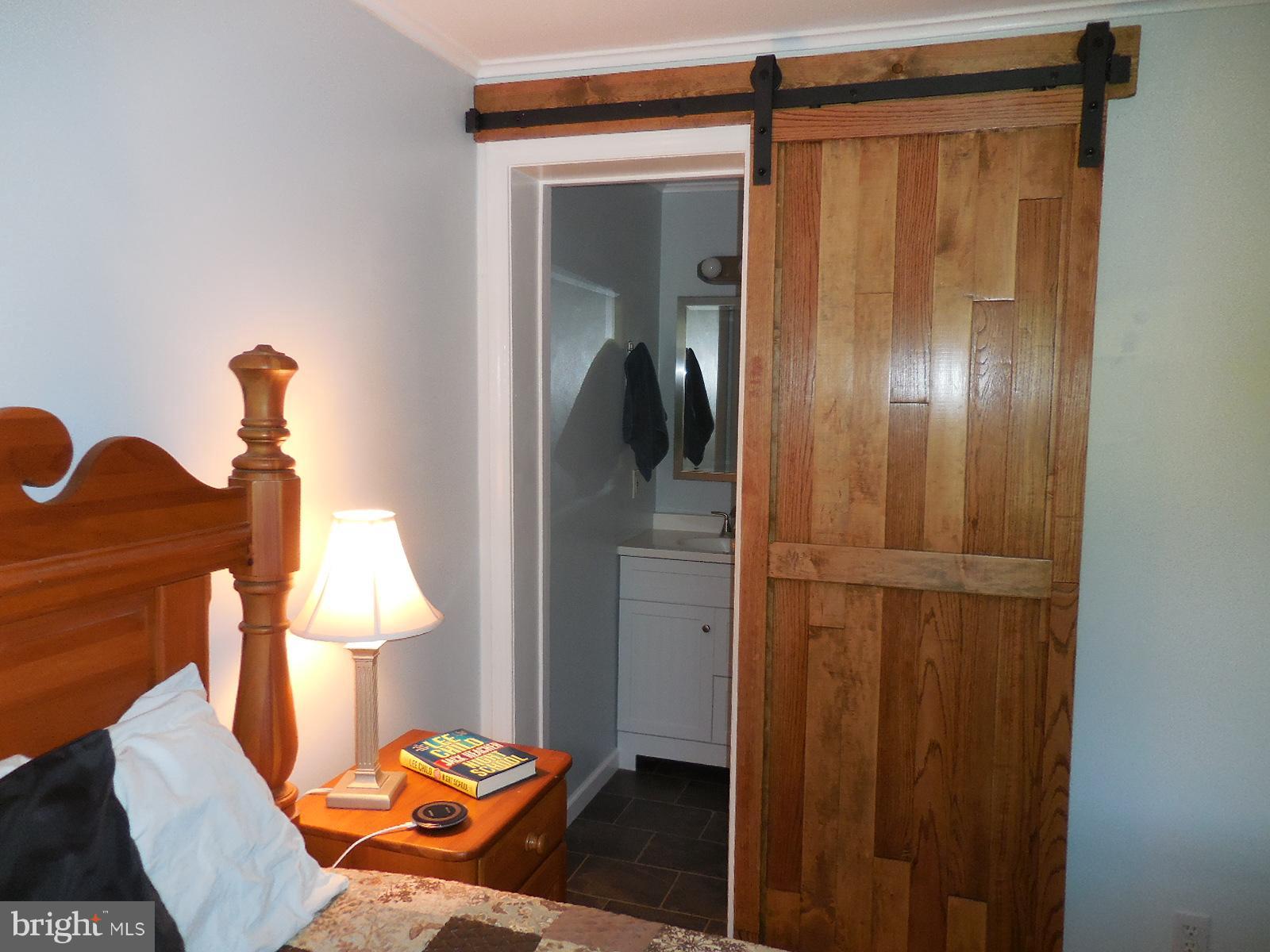 250 Outpost Road Luray, VA 22835 - Photo 21 of 25 a bedroom with a bed and a lamp on table