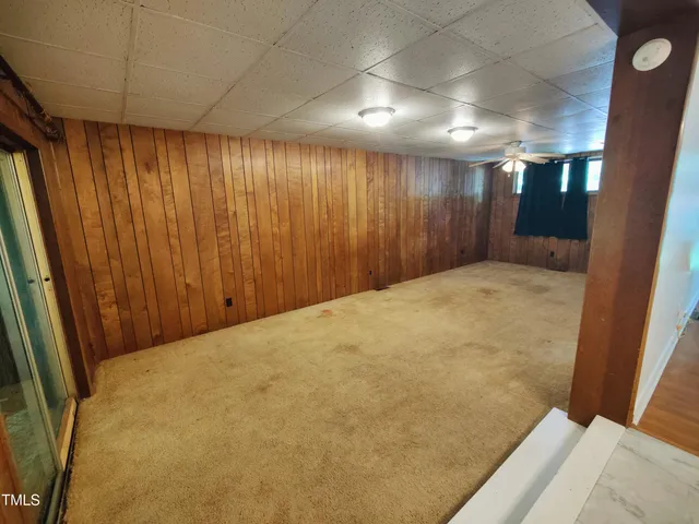 en empty room with windows and fireplace