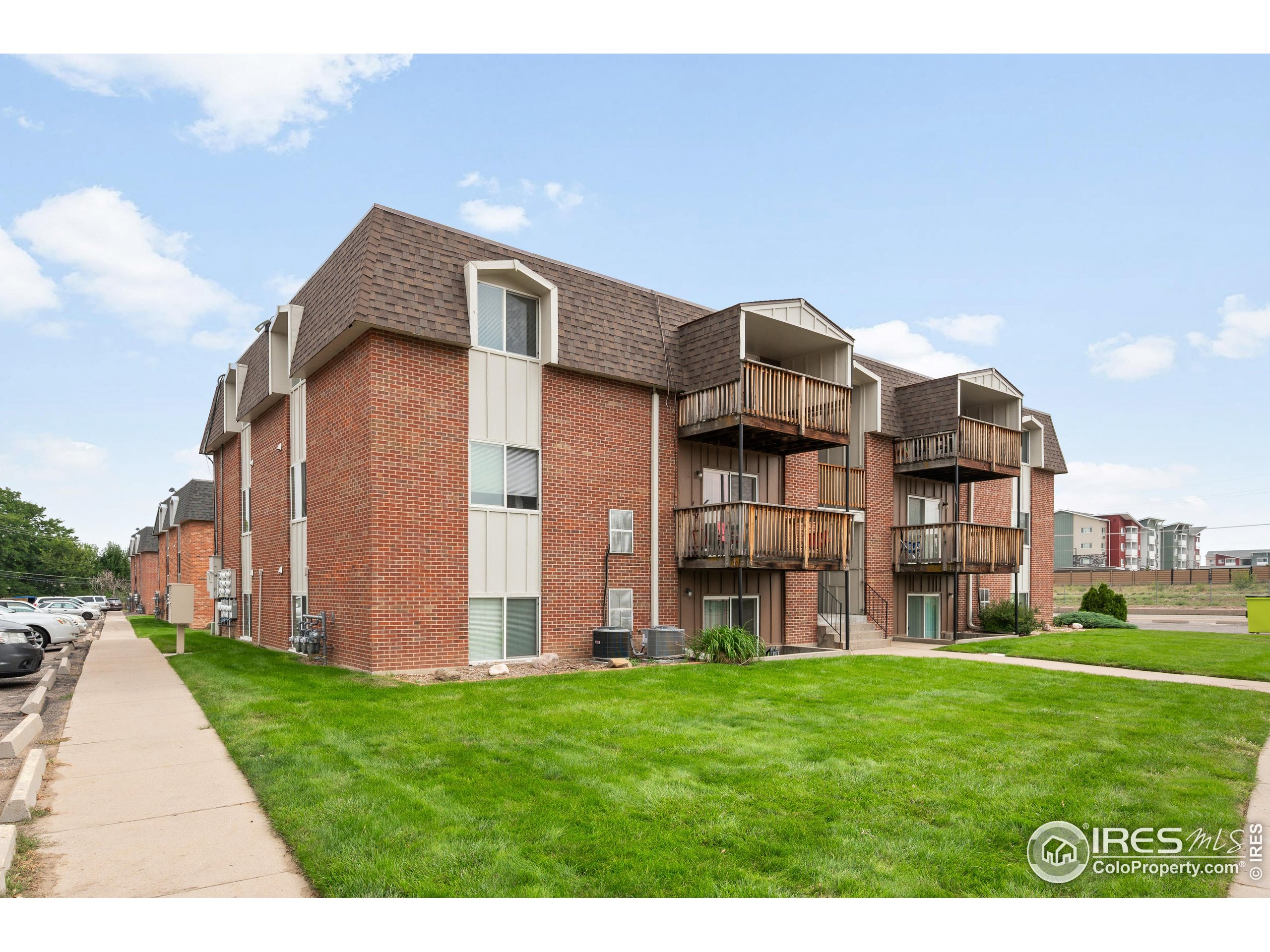 a view of a big house with a big yard plants and large trees