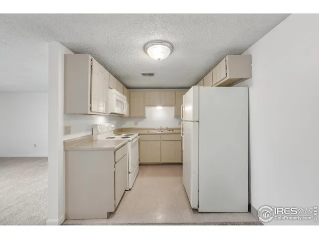 a kitchen with kitchen island white cabinets and refrigerator