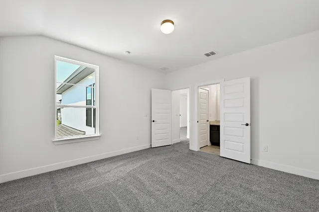 a view of an empty room with a window and cabinet
