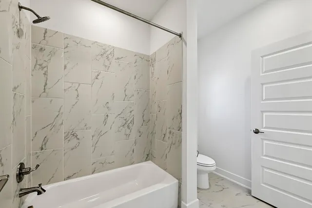 a bathroom with a toilet and shower