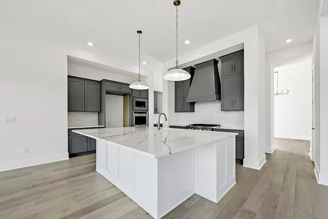 a large kitchen with stainless steel appliances kitchen island a large counter top and a sink