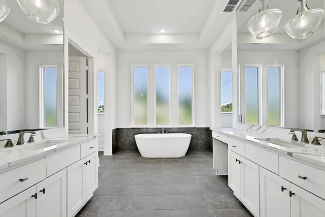 a bathroom with a granite countertop sink and a bathtub