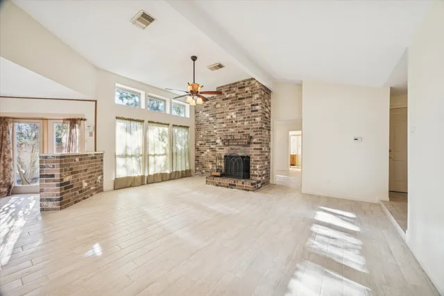 a kitchen with stainless steel appliances granite countertop a stove top oven a sink dishwasher a dining table and chairs with wooden floor