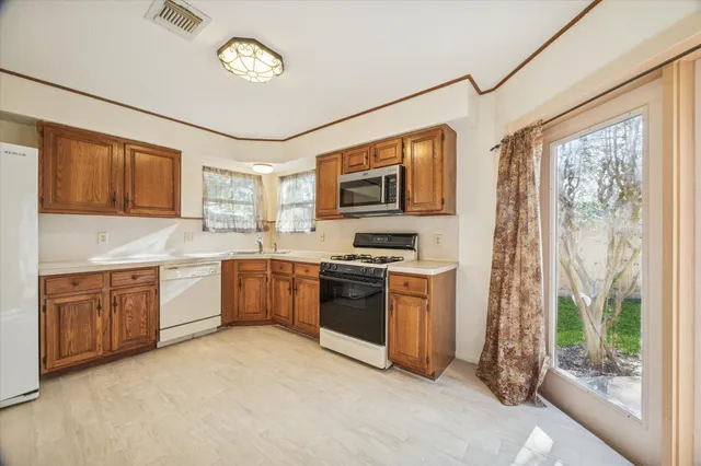a kitchen with granite countertop a sink stove and refrigerator