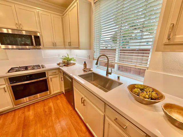 a kitchen with stainless steel appliances a stove a sink and a microwave