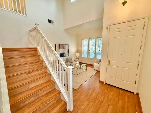 a view of a livingroom with wooden floor and stairs