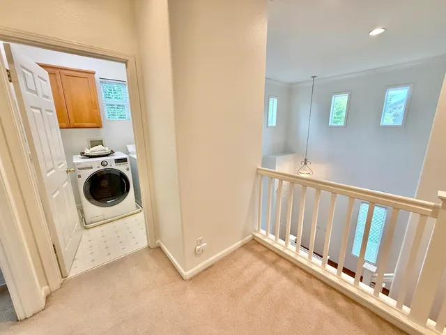 a view of a kitchen with a sink and a washer dryer