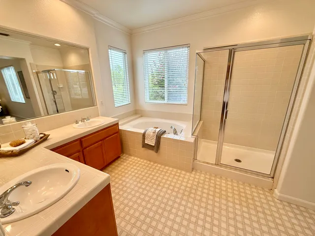 a en suite bathroom with a tub sink and mirror